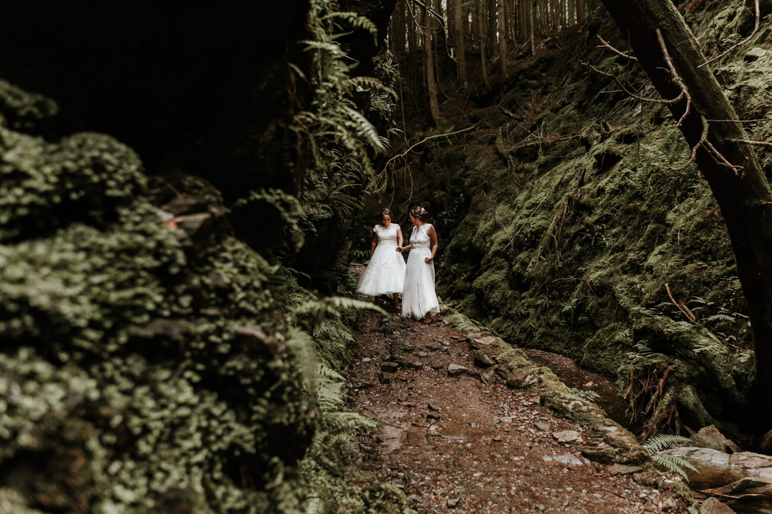 two brides walking through scottish woods