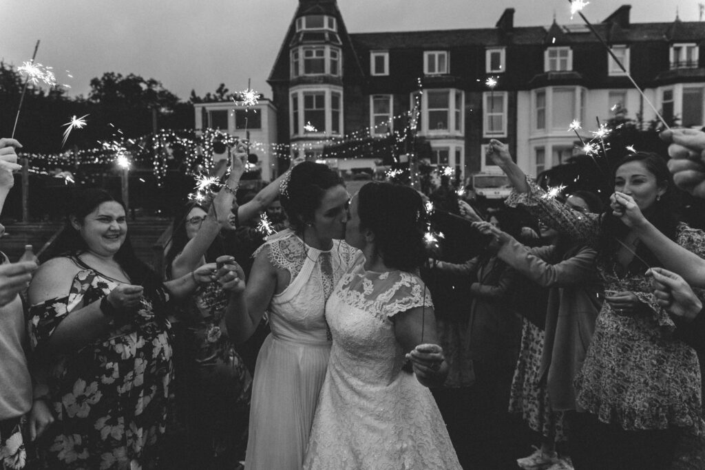 two brides kissing with sparklers