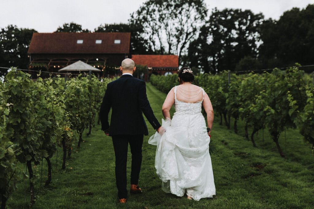 South West England wedding photography of couple walking through a vineyard
