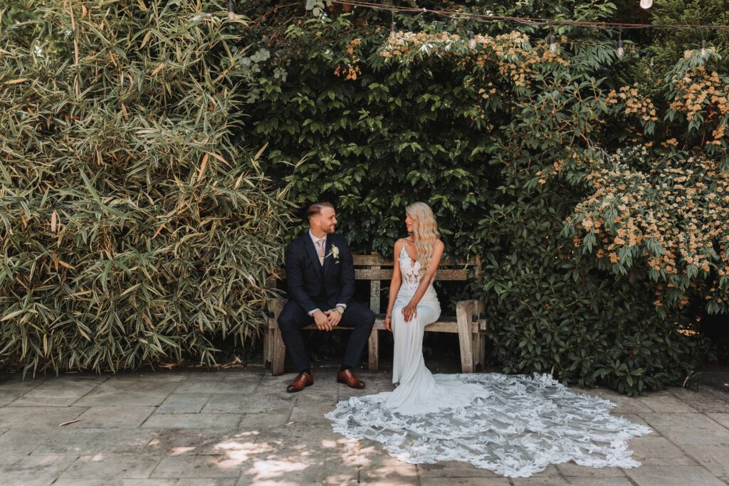 careys-manor-wedding-14 bride and groom looking at eachother on a bench