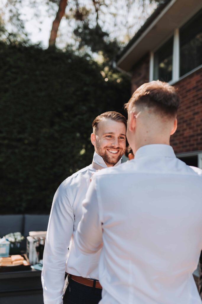 groom having his tie done up