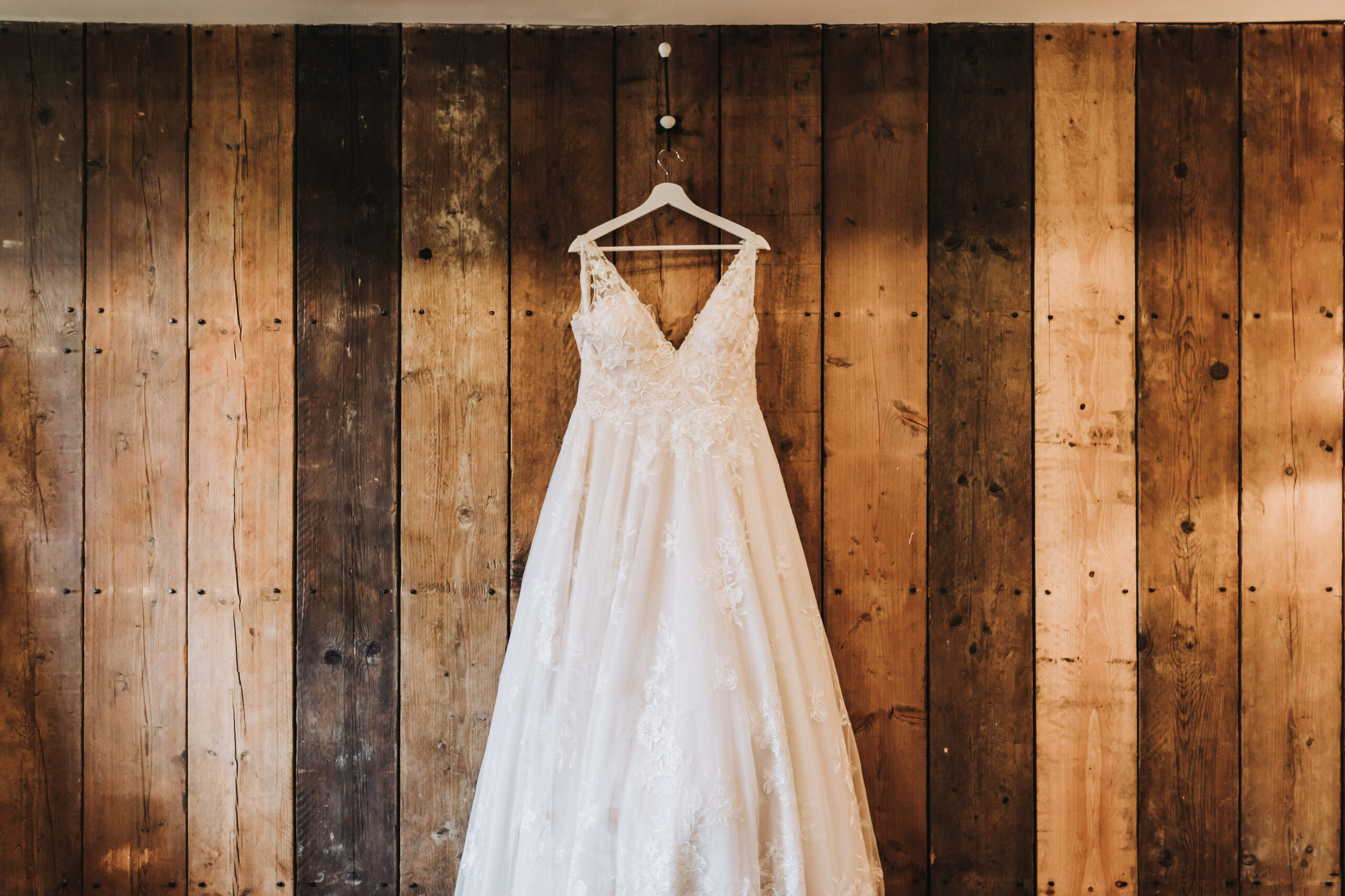 wedding dress hung in stables