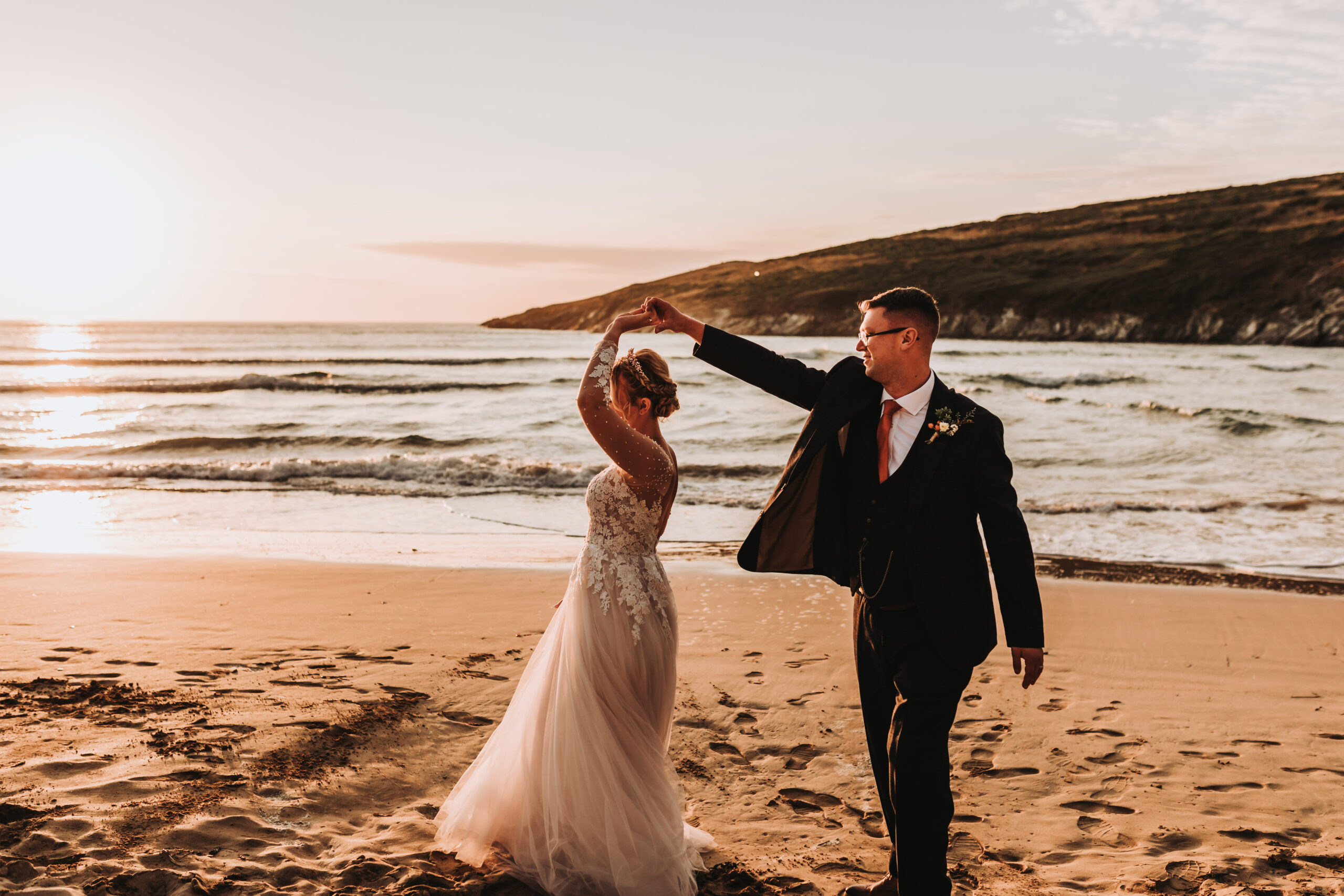 groom spinning bride on cornish beach