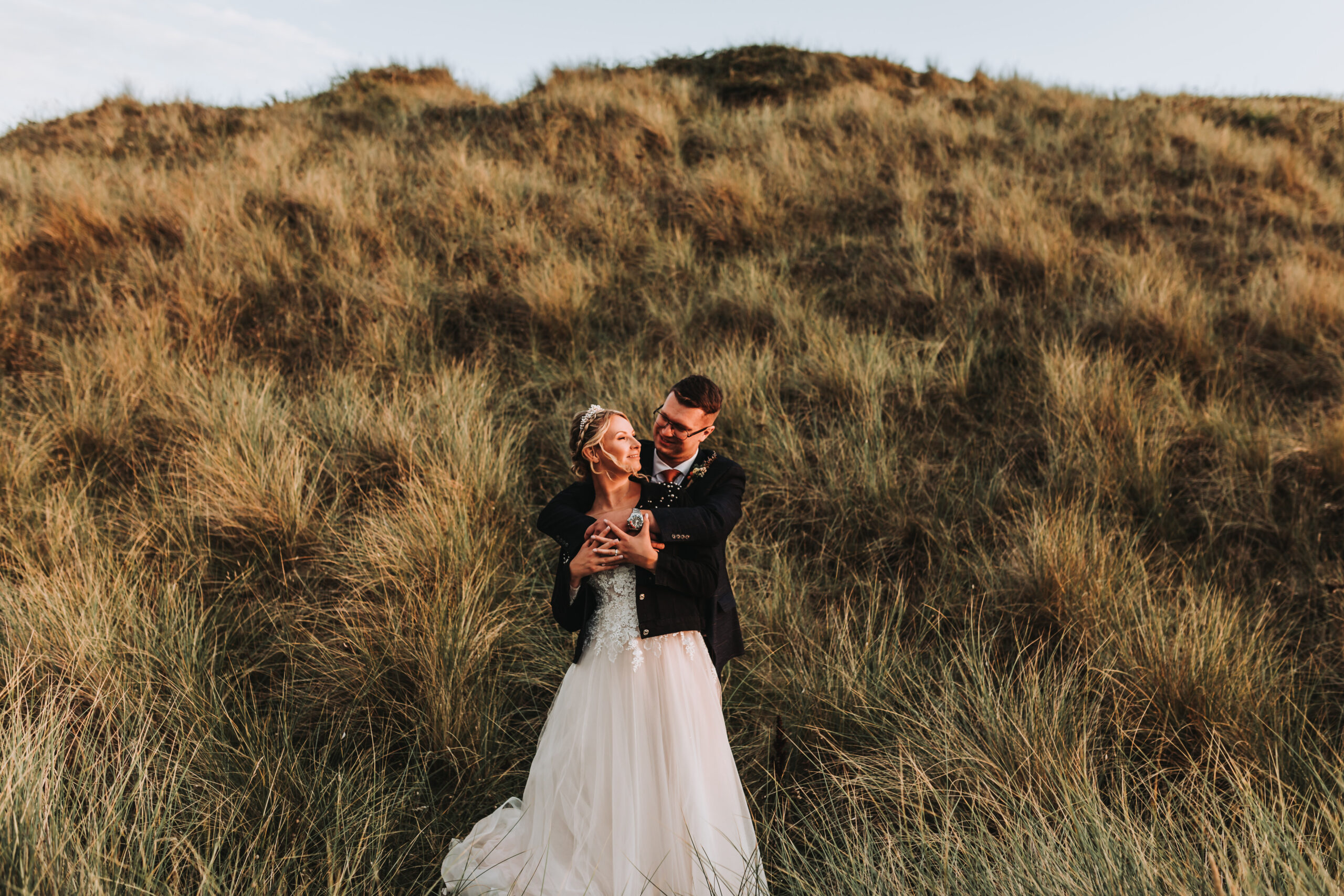 bride and groom in sand dune
