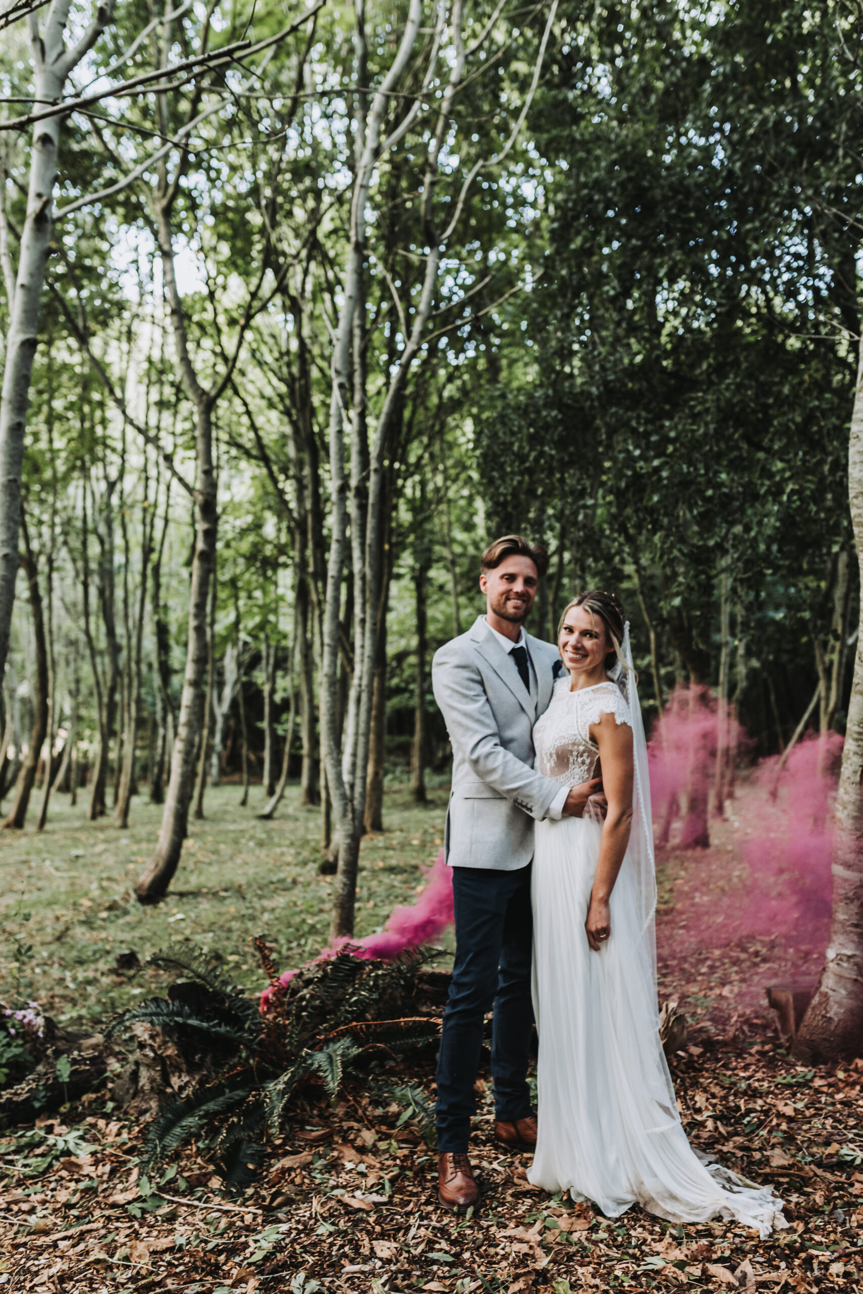 bride and groom smiling in woodland photoshoot