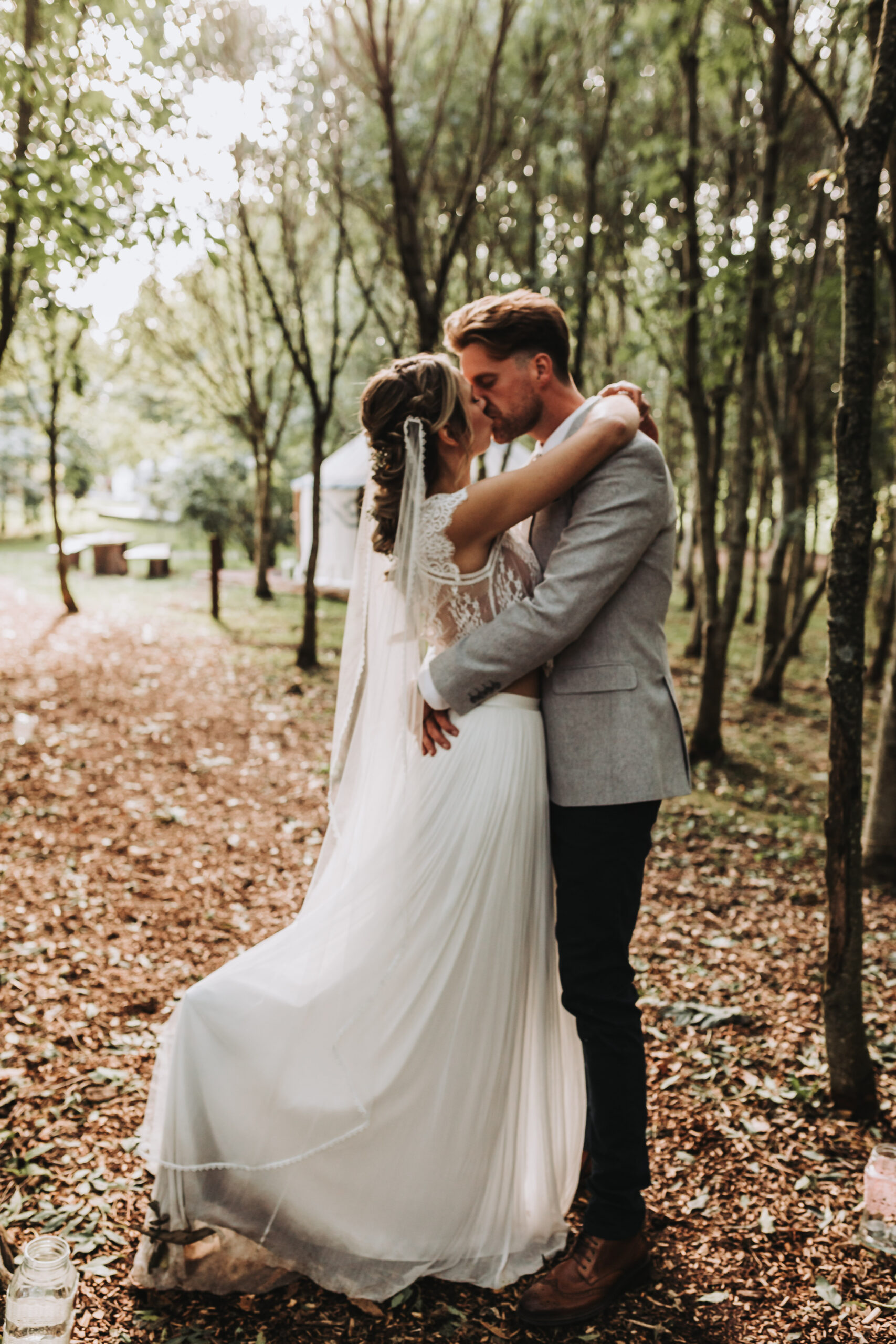 married couple kissing at woodland wedding