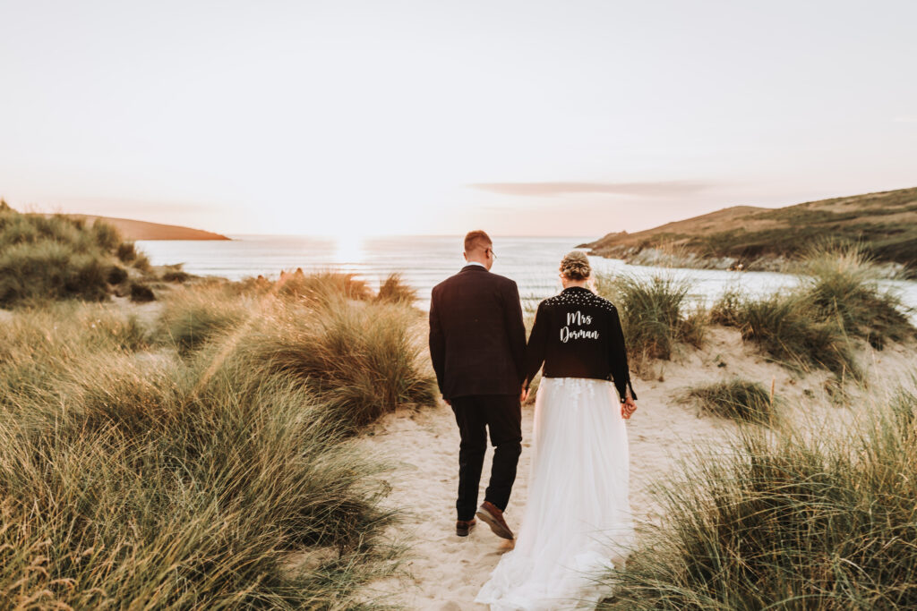 bride and groom walking at cornish beach