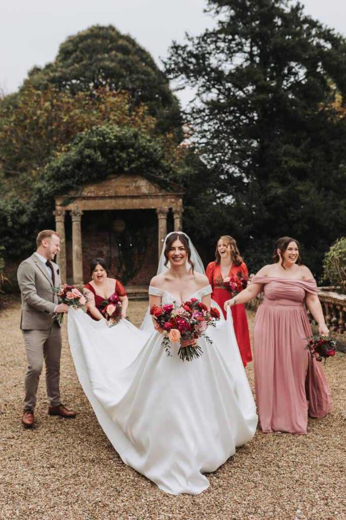 bridal party holding brides dress at brympton house