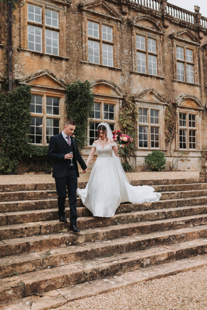bride and groom walking down steps at wedding venue in south west england