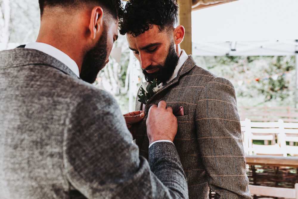 buttonhole getting put on grooms suit