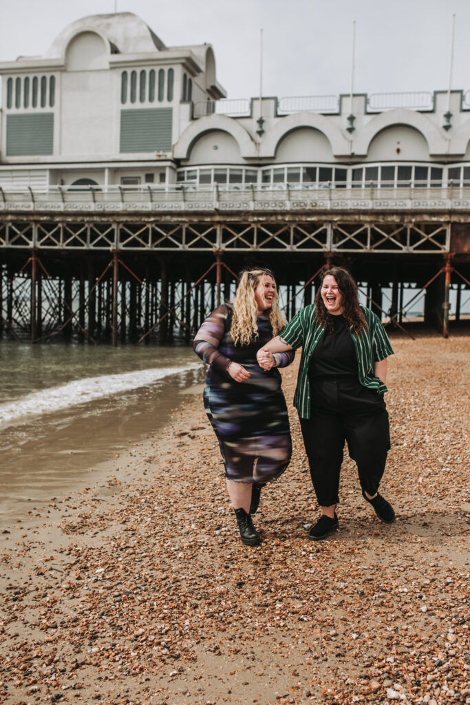 lgbtq+ couple near a pier