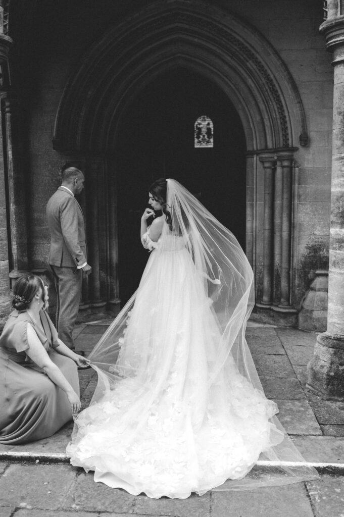 bride outside romsey abbey by hampshire weddphotographerng  