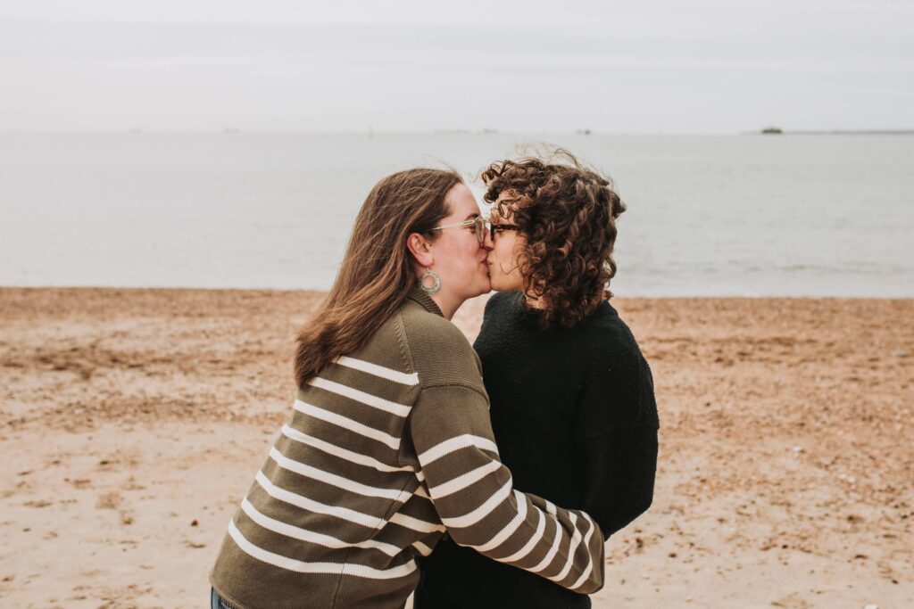two girls kissing tightly on southsea beach