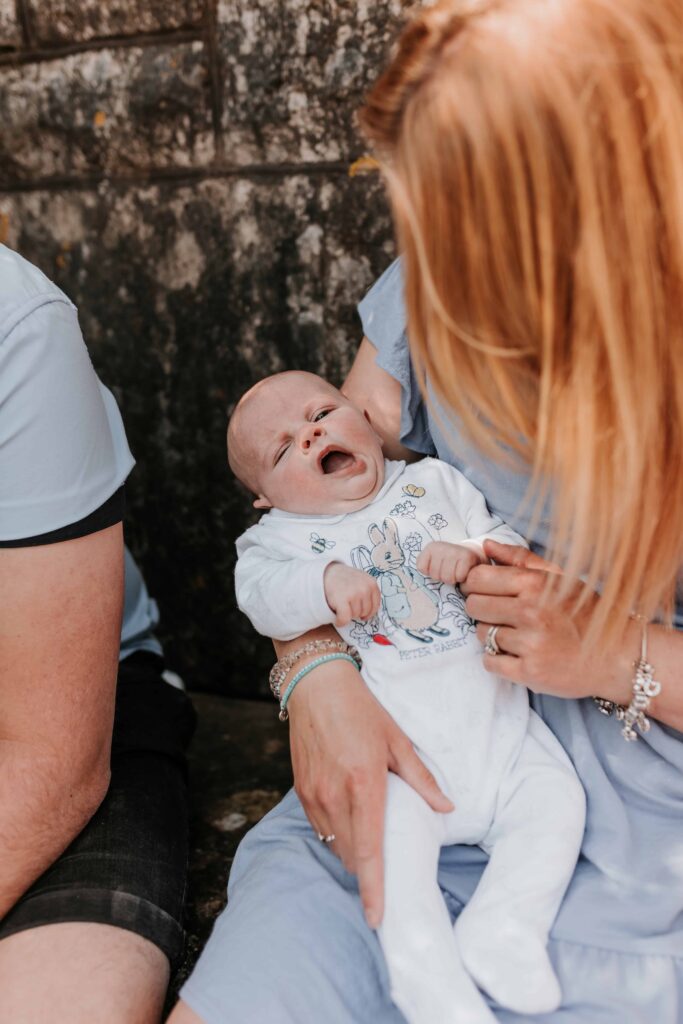 little baby boy yawning in his mums arms