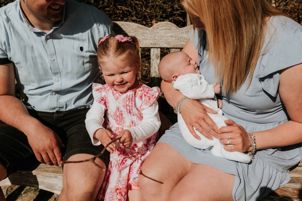 family of four sitting on bench together