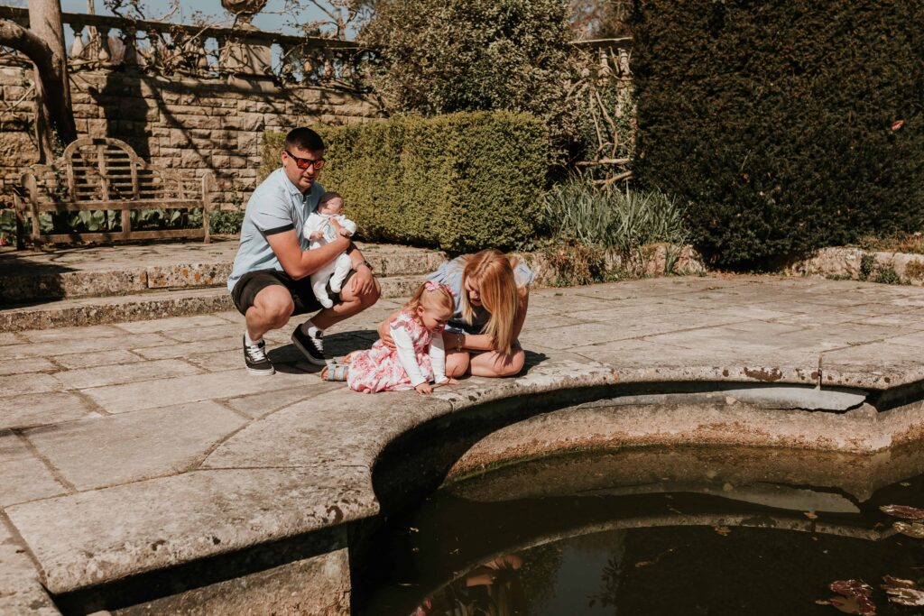 family of four together looking into a fish pond