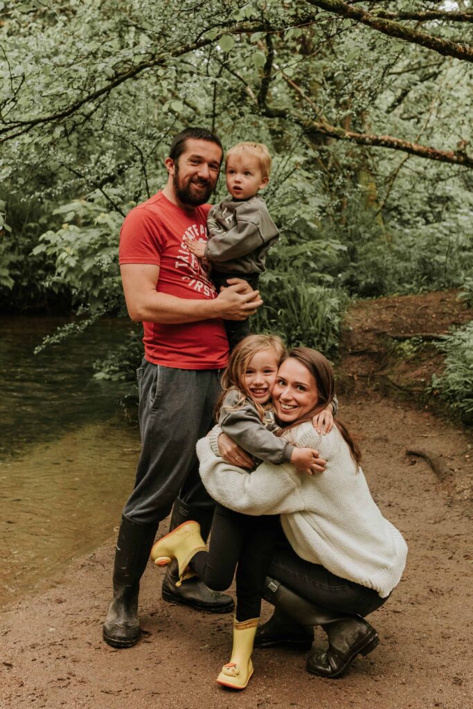 mum and daughter cuddling whilst dad holds son on his hip behind them