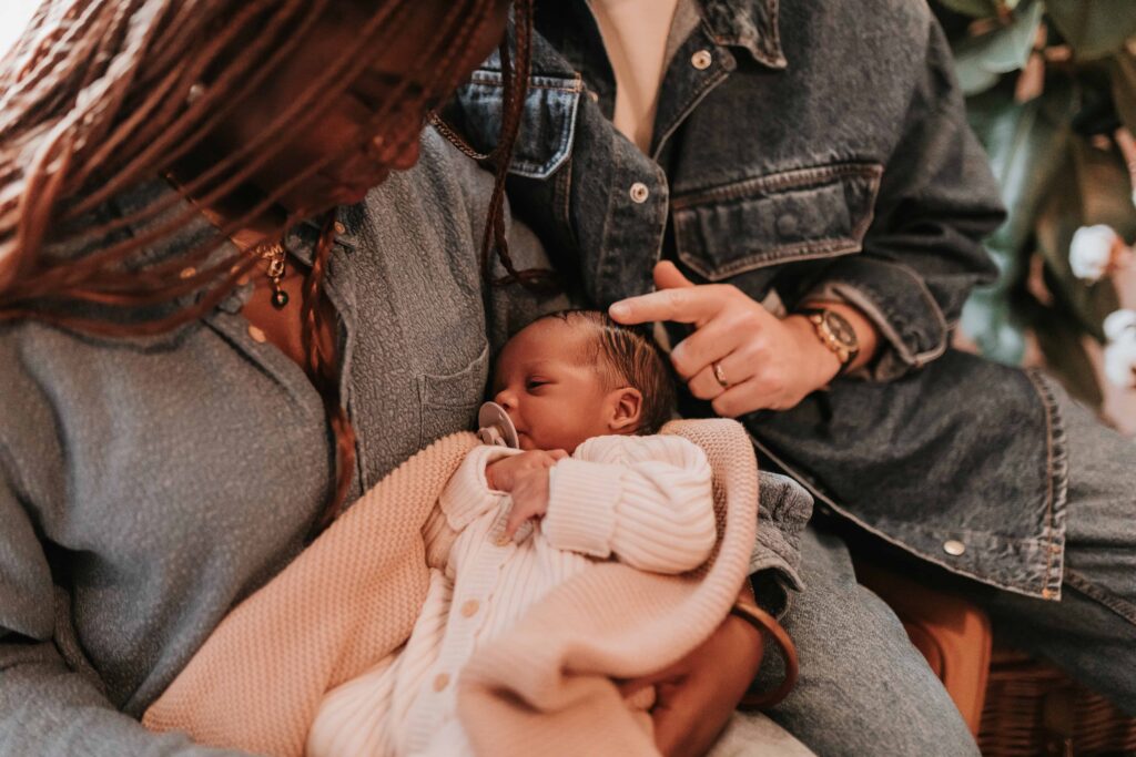 woman holding newborn baby whilst dad strokes her head at maternity & newborn photoshoot