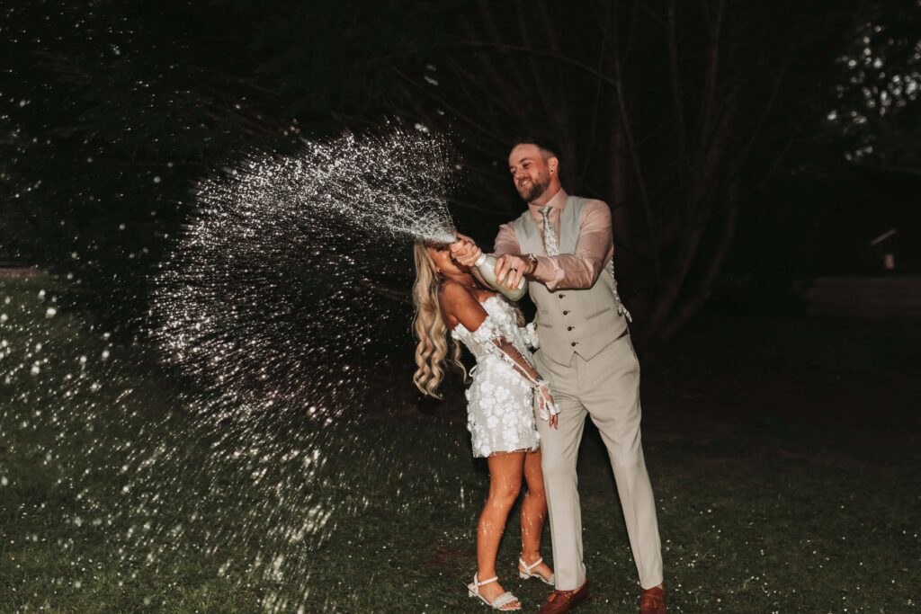 bride and groom spraying champagne at chycara wedding
