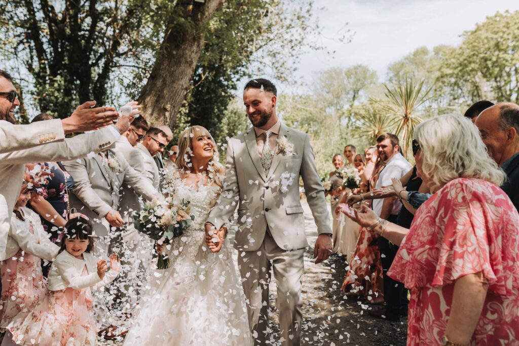 bride and groom walking through confetti line at chycara wedding
