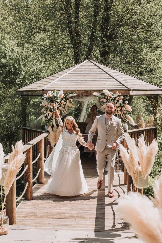bride celebrating as they walk down the aisle married