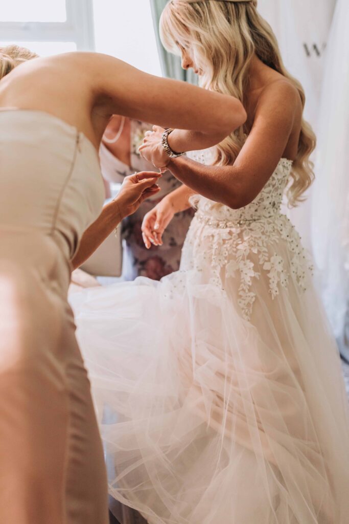 bridesmaids putting a bracelet on the bride