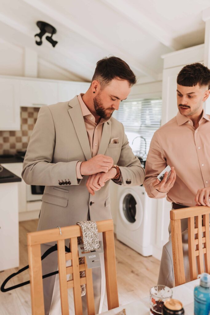 groom and groomsman adjusting watch at chycara wedding
