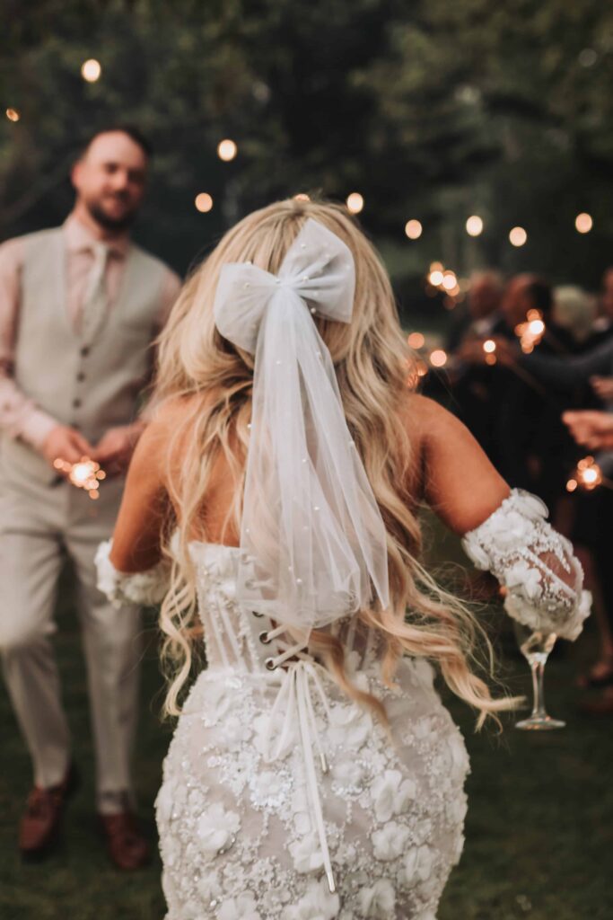 bride wearing short wedding dress with bow in her hair
