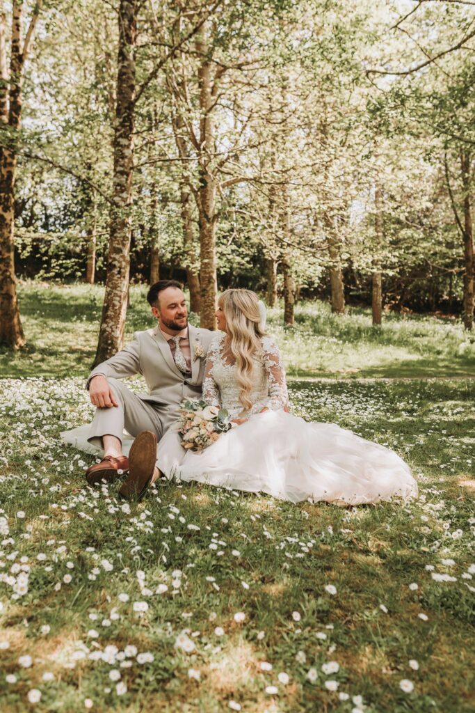 bride and groom sitting in daisys
