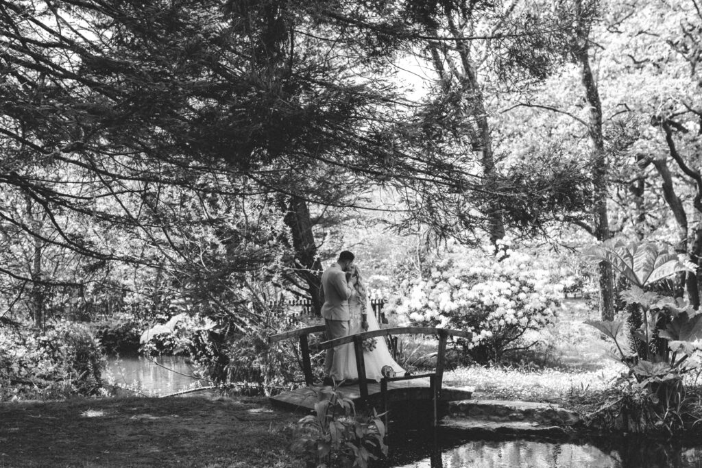 bride and groom standing on bridge at chycara wedding