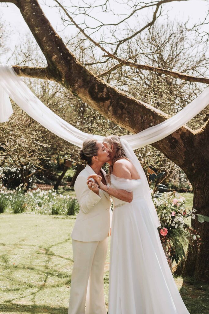 two brides kissing at the end of the aisle