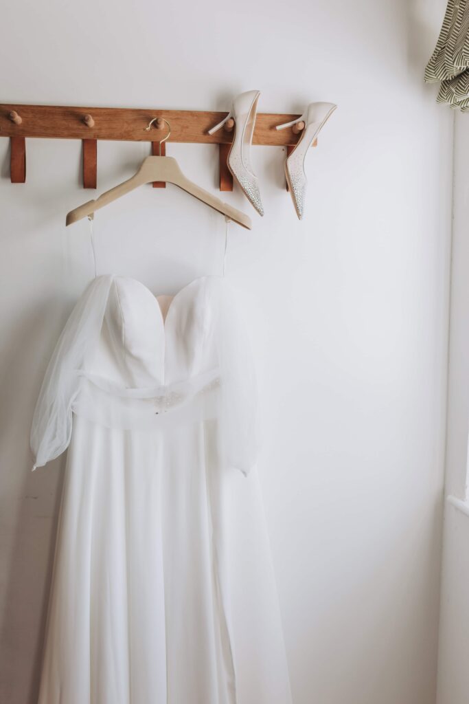 white wedding dress hung up photo by lgbtq+ wedding photographer