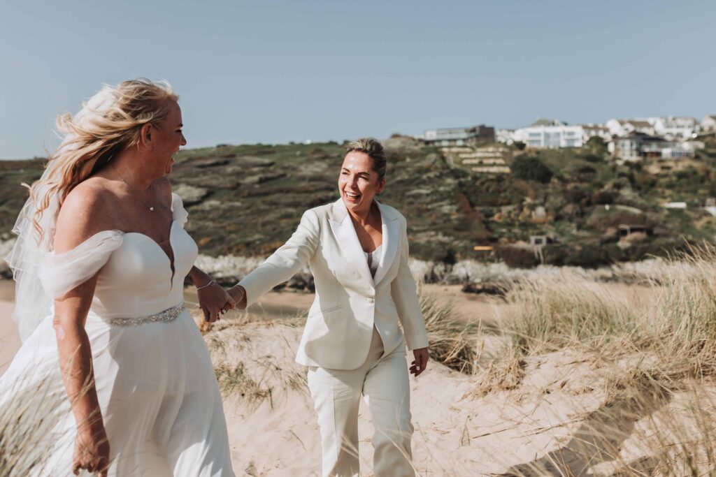 bride in yellow suit smiling at her wife