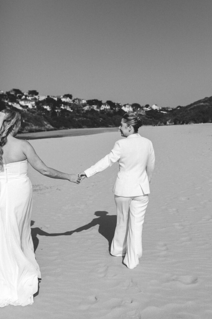 brides walking holding hands on crantock beach