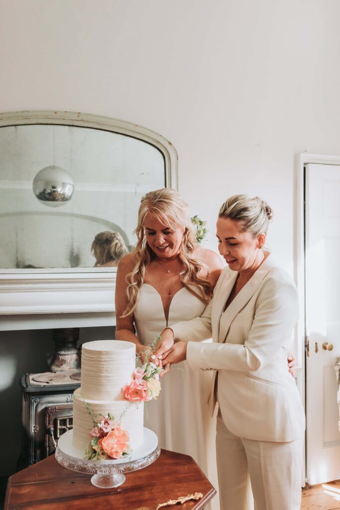 brides cutting cake at treseren photo by lgbtq+ wedding photographer