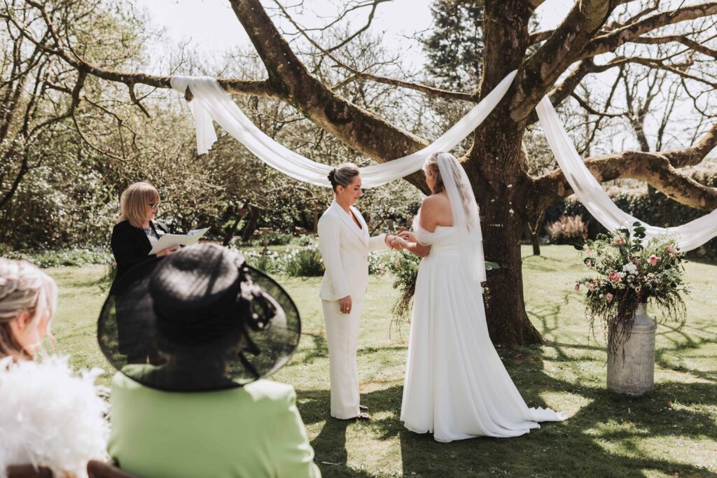 two brides exchanging rings under walnut tree