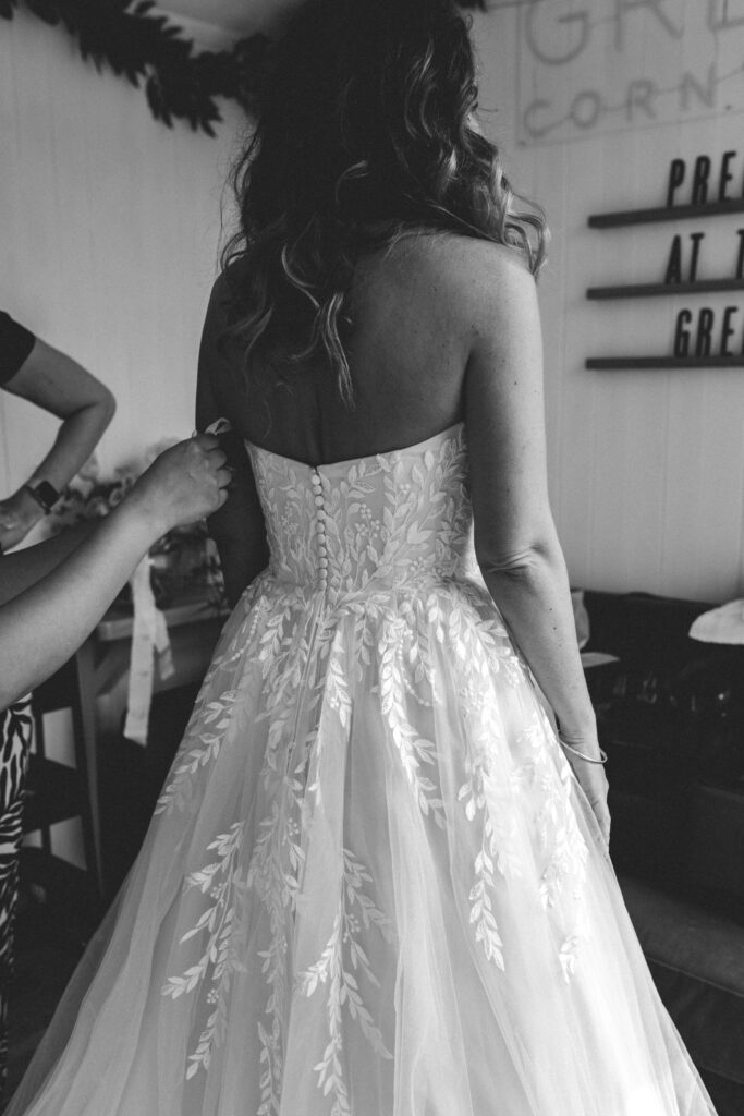 bride having her dress done up
