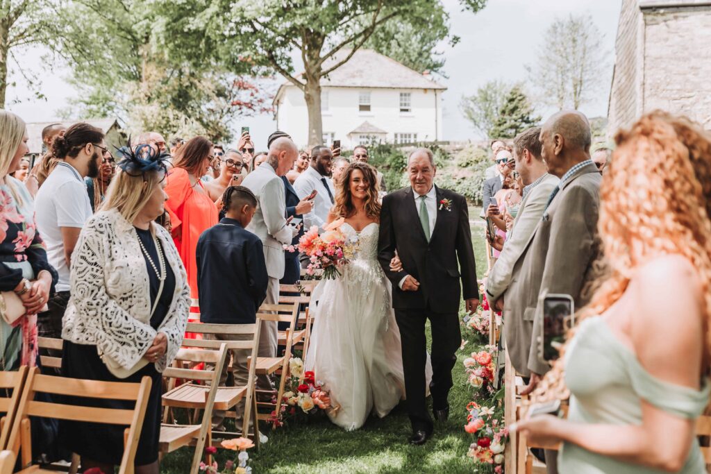 bride and dad walking down the aisle at the green cornwall