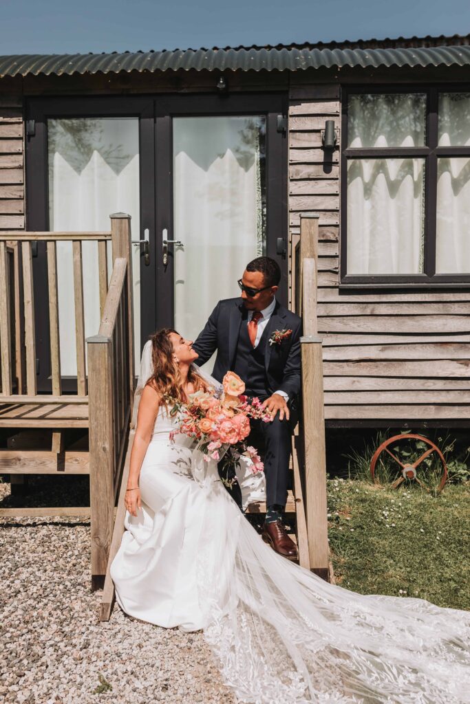bride and groom sitting together at the green cornwall