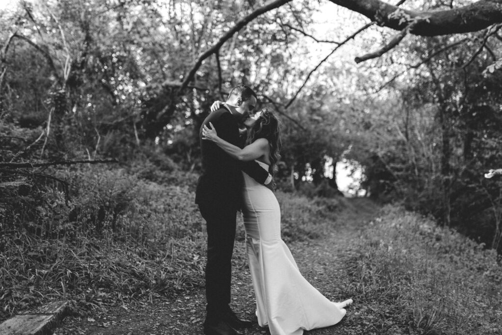 bride and groom holding eachother in field at the green cornwall
