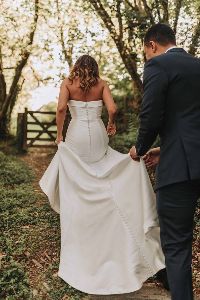 groom holding brides train at the green cornwall