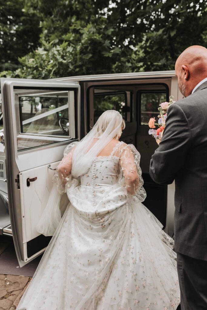 bride getting into vintage car at bristol wedding
