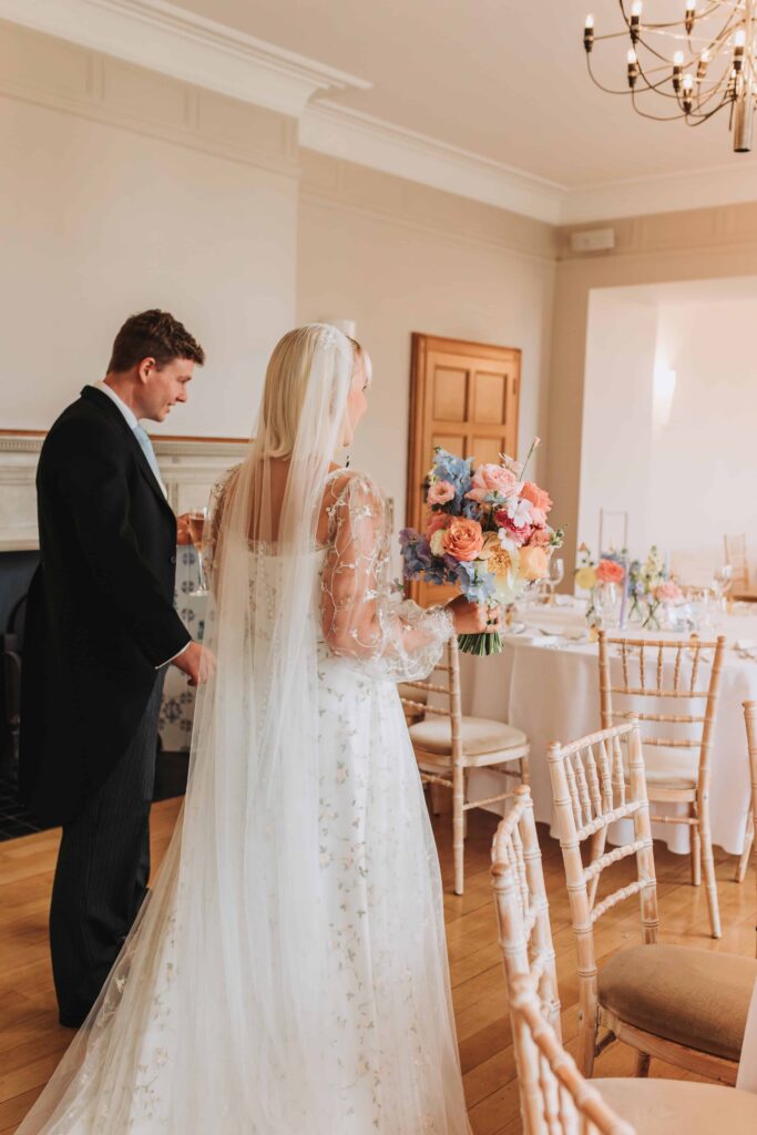 bride and groom looking around wedding breakfast set up at coombe lodge