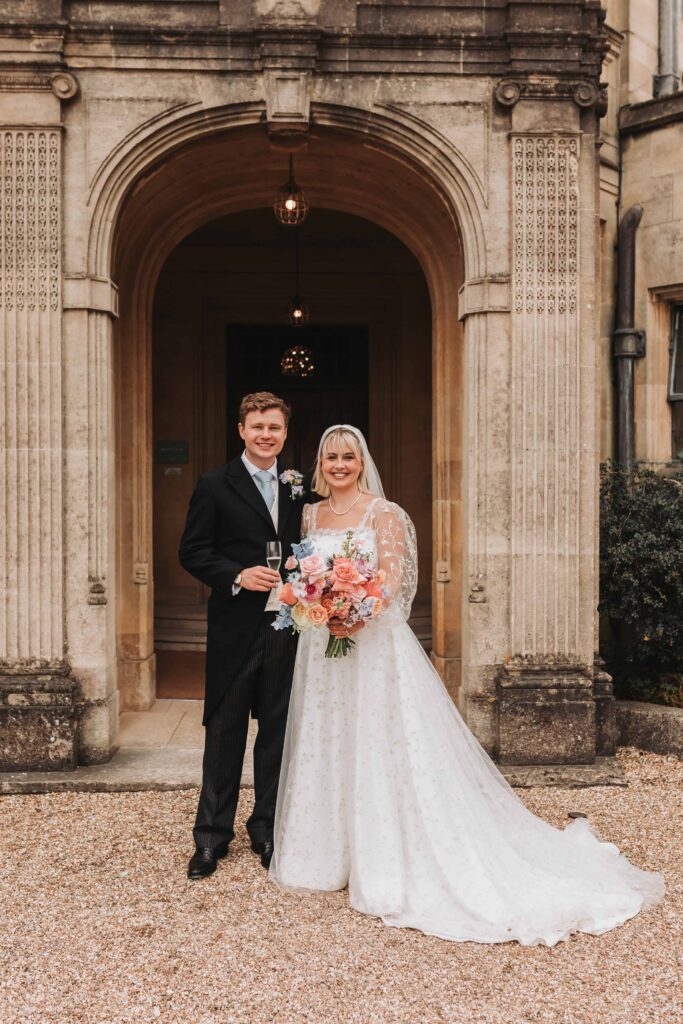 bride and groom stood outside coombe lodge blagdon