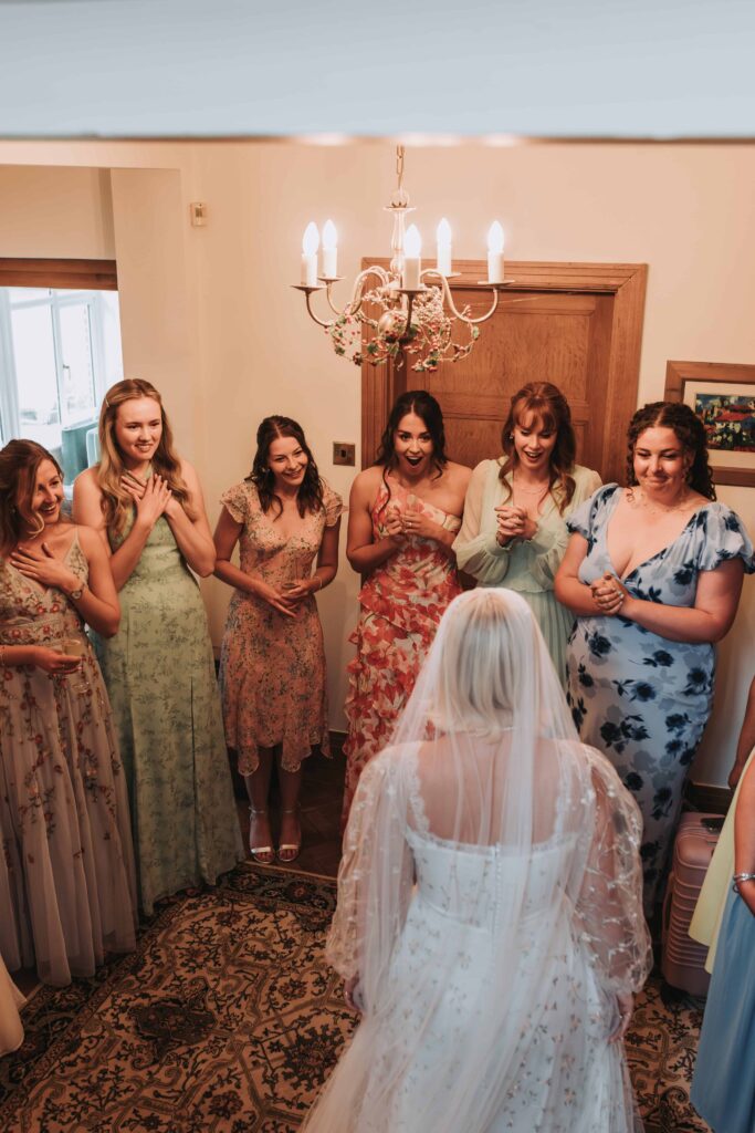 bridesmaids reaction to bride coming down stairs in wedding dress