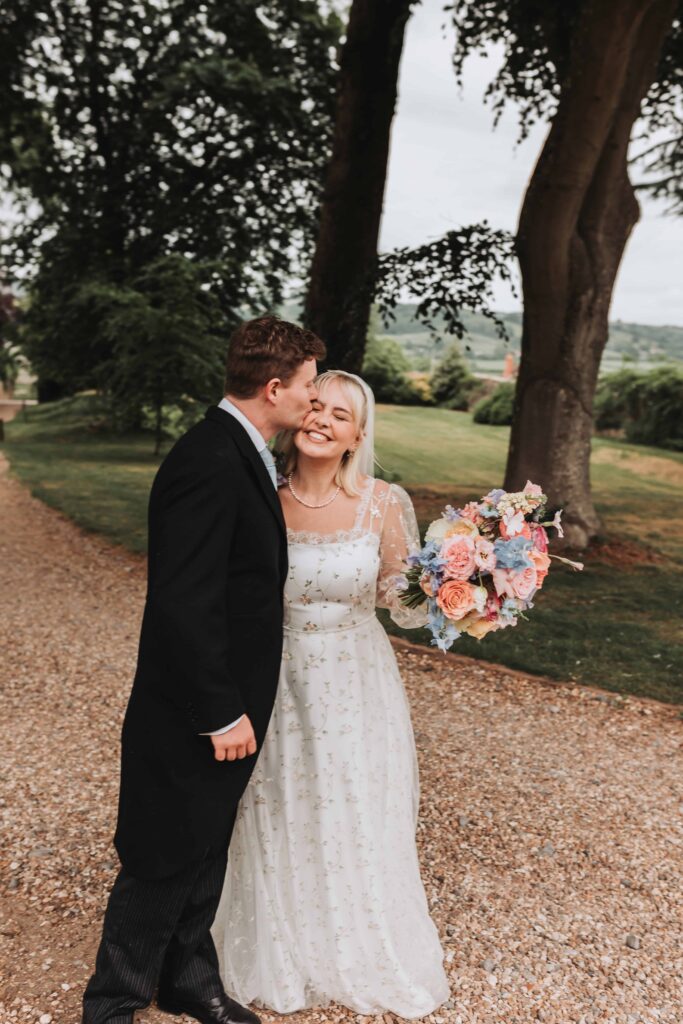 groom kissing bride on the cheek