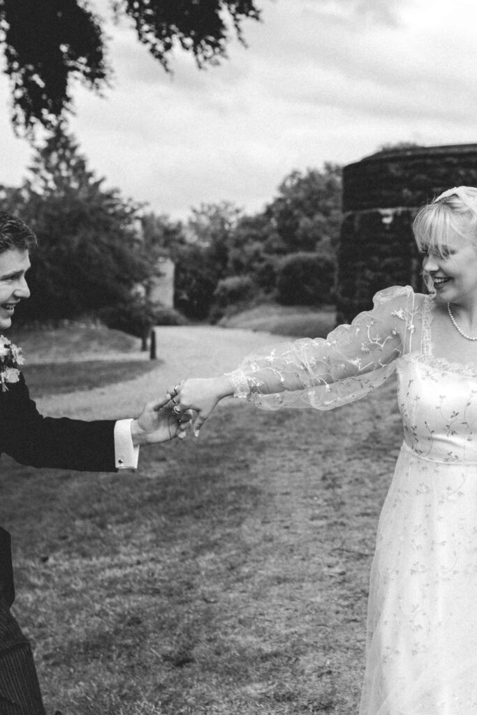 bride and groom holding outstretched hands