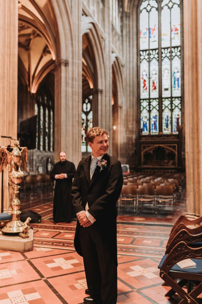 groom looking at bride down the aisle in church