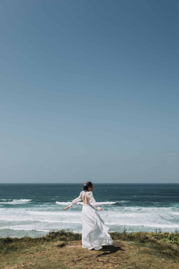 bride embracing windswept cliff face