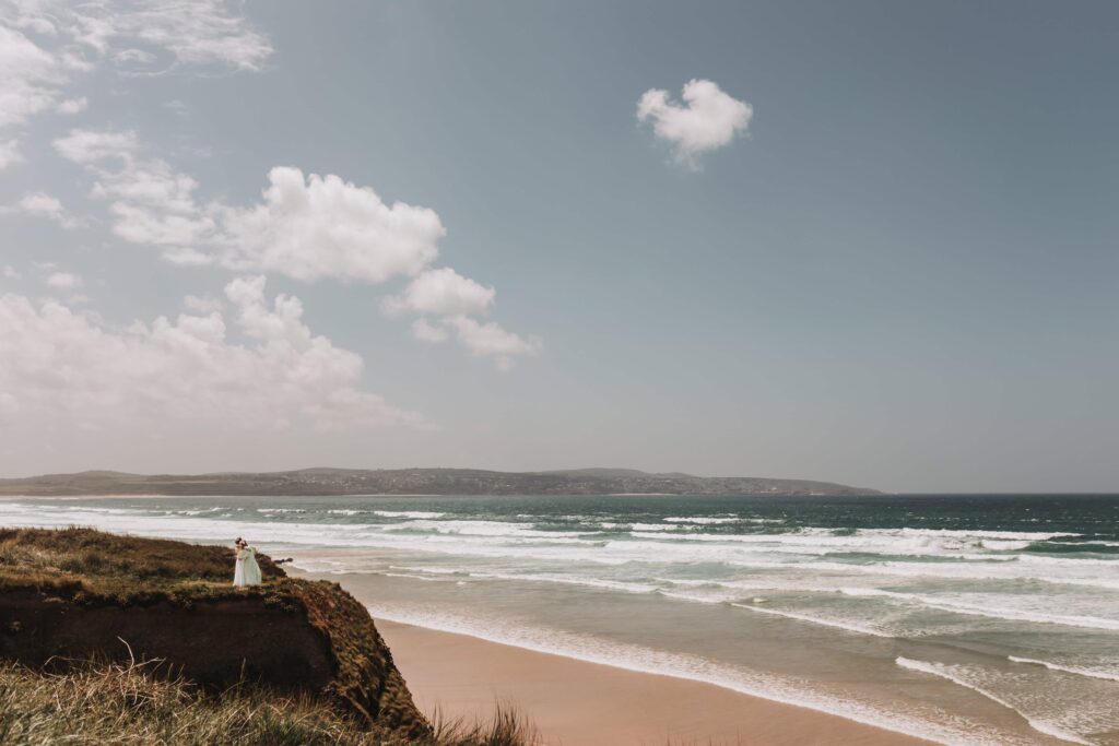 brides looking over cornish cliff at st ives